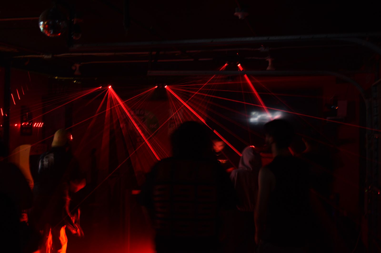 Red lasers fanning out over the heads of a crowd, a disco ball at the edge