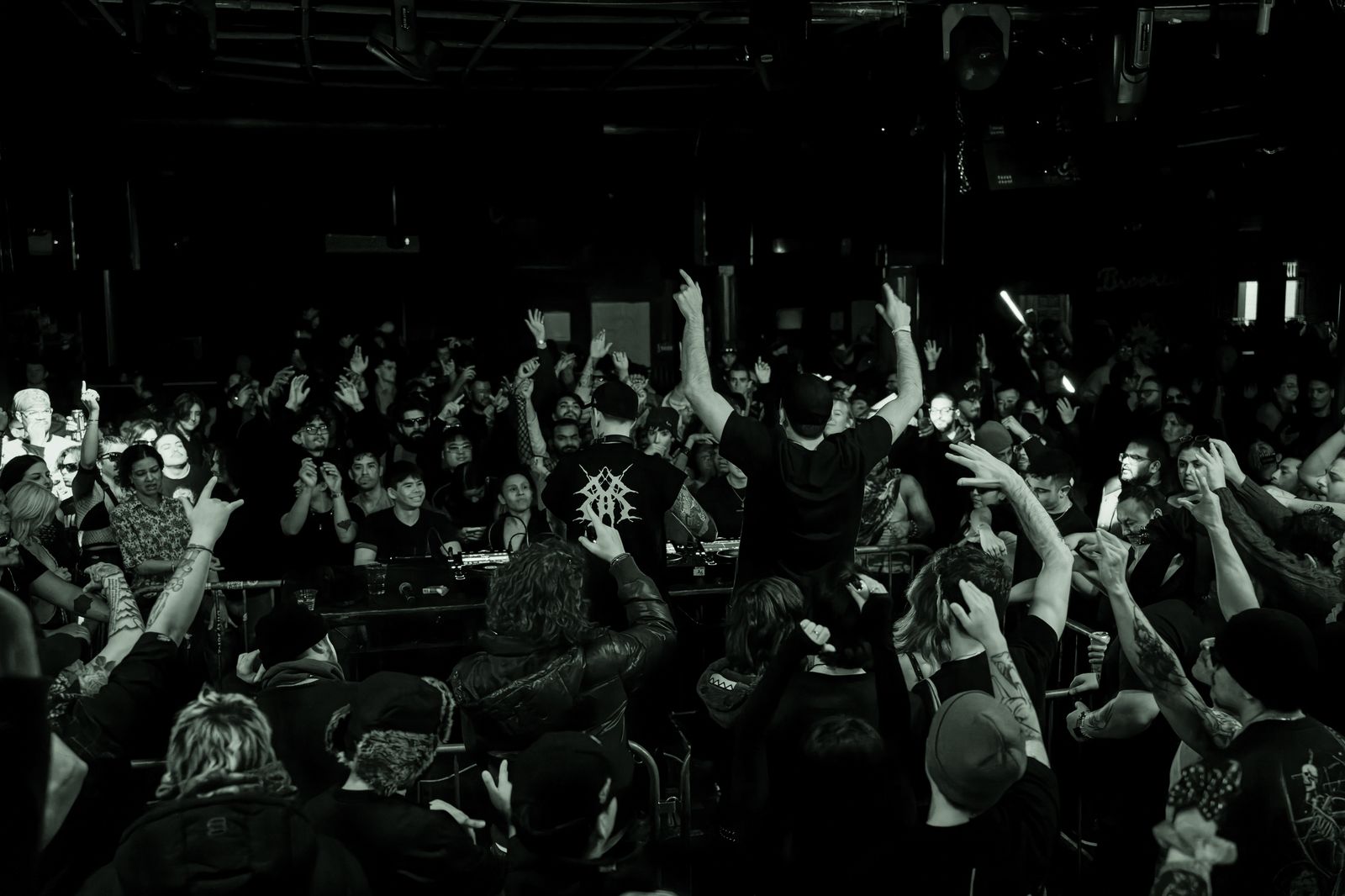 Kronos commands the Monarch floor, arms raised against a wall of hands.