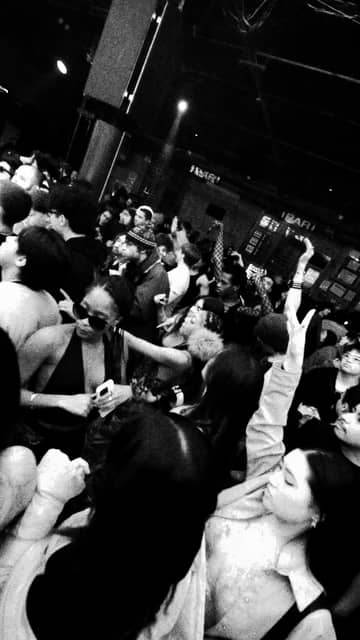 A packed dance floor, hands up