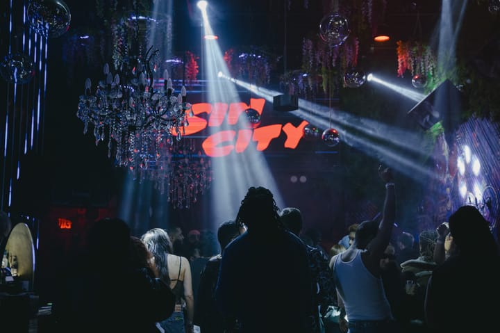 Sin City glows red over the floor as crystal chandeliers and beam light cut through the room at Listen.